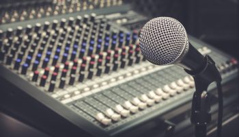 The producer music or musician equipment concept.Selective focus of single microphone with sound music mixer at the recording studio room.Vintage tone design background.